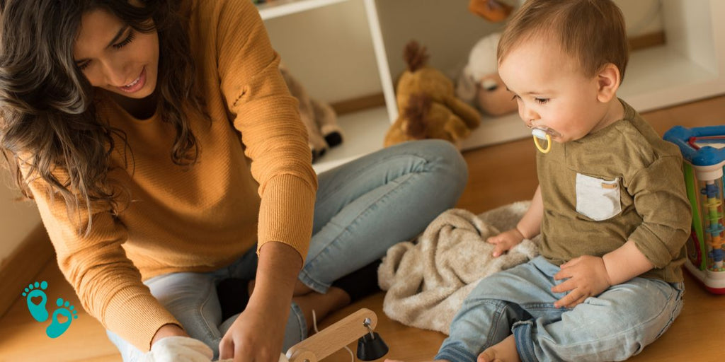 Parent and baby playing together on the floor, baby wearing cozy clothes, perfect for Grookz baby shoes