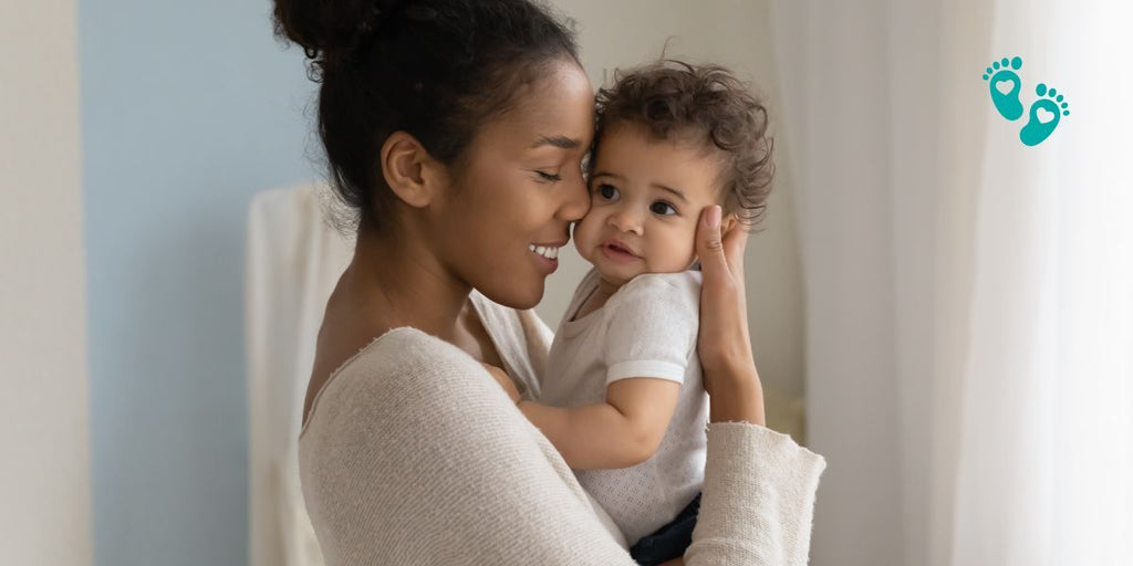 Mother holding her baby wearing Grookz baby sock shoes, highlighting comfort, style, and safety.