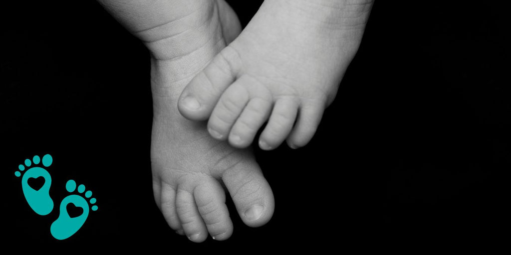 Close-up of baby feet against a black background, exploring whether baby shoes need arch support in a comprehensive guide for parents from Grookz Shoes