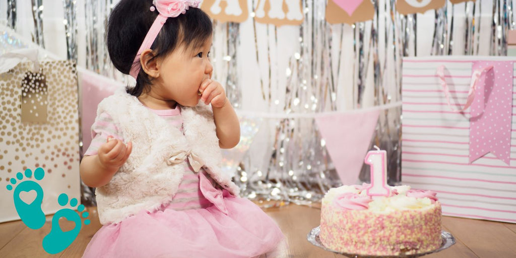 Baby girl celebrating her first birthday with a cake, highlighting Grookz baby shoes as the best choice for new walkers