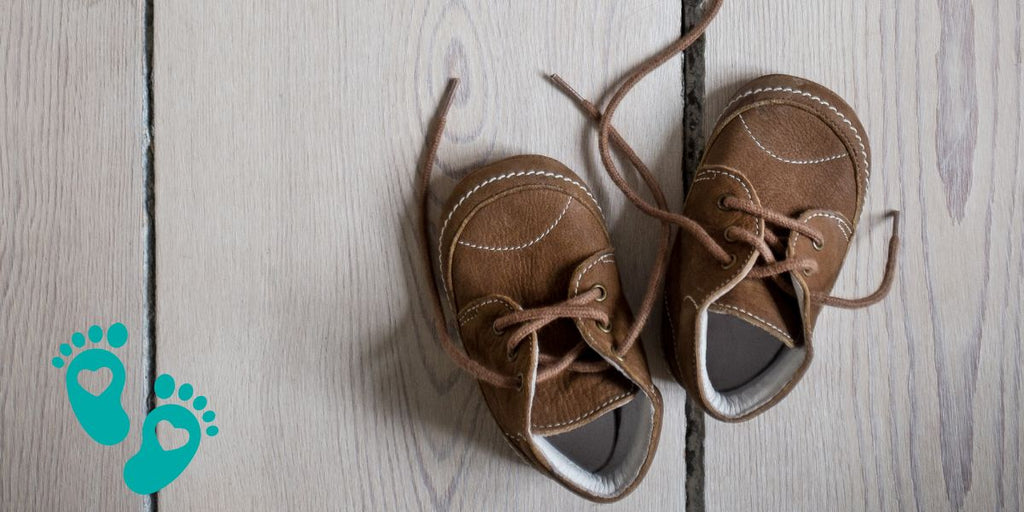 Pair of brown baby shoes on a wooden floor, highlighting the ultimate baby shoes for new walkers with Grookz Shoes Guide