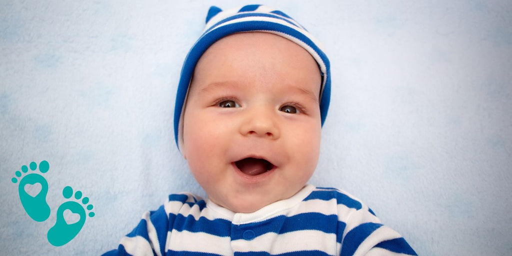 Smiling baby in a blue and white striped outfit and hat, discussing baby shoes recommended by podiatrists with Grookz Shoes