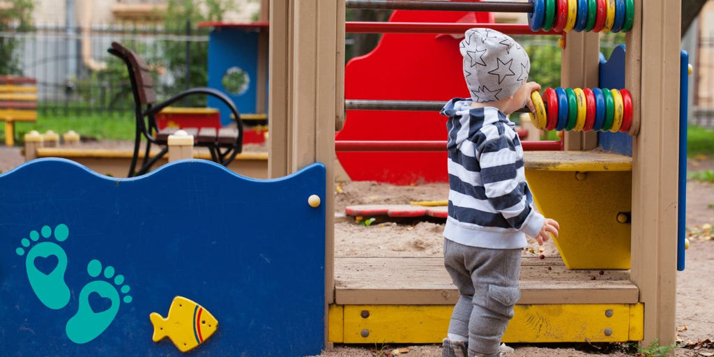 Toddler playing at a playground, discussing whether baby shoes are bad for babies and unraveling the truth about baby footwear with Grookz Shoes